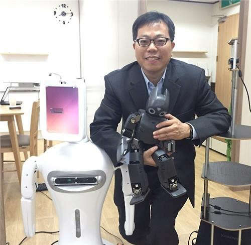 '엄마로봇'을 개발 중인 서울대 컴퓨터공학부 장병탁 교수. 사진 왼편의 하얀색 로봇이 '엄마로봇'.